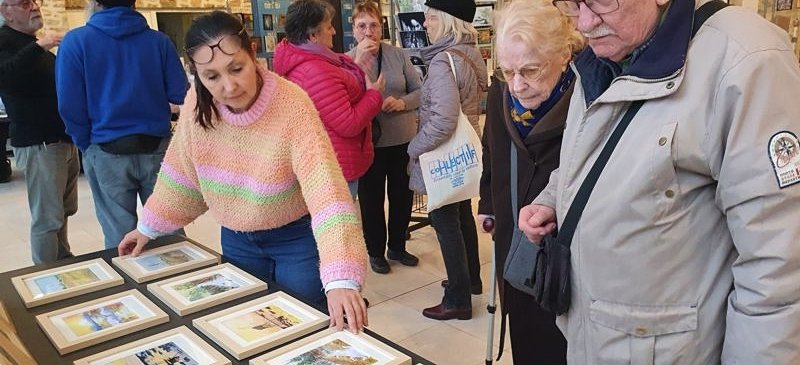 Isabelle Morin (à gauche) présentant ses aquarelles lors de l’exposition “Artistes Solidaires 2025” à Pontault-Combault. Elle vendra onze de ses œuvres d’art pendant le week-end.
