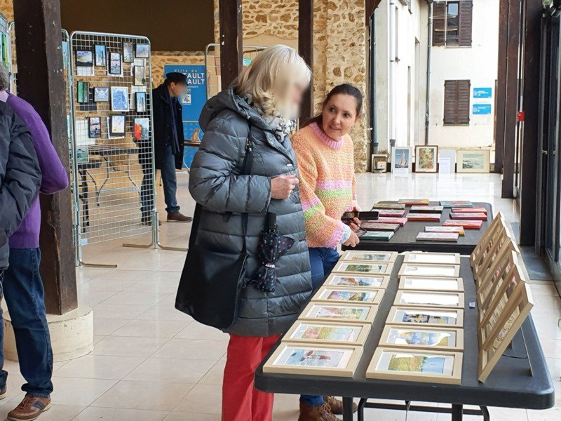 Isabelle Morin (à droite) présentant ses aquarelles. Elle en vendra onze. 