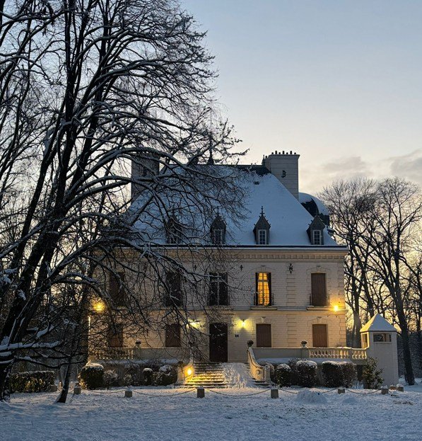 Vue extérieure enneigée du Château du Bois-la-Croix un soir d'hiver, fenêtres éclairées, lieu de la conférence Team France à Pontault-Combault. 