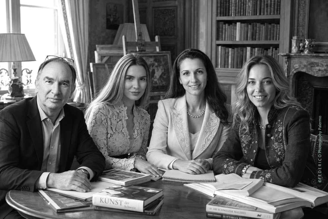 Photographie du portrait de groupe de l'équipe de la Galerie d'art en ligne Koronin dans une bibliothèque, à Chur, en Suisse.