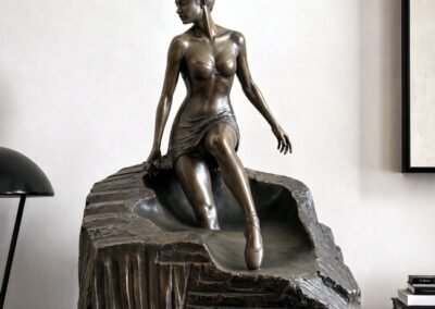 Sculpture contemporaine en bronze d'Ayla Woss représentant une danseuse s'émancipant d'un socle massif, exposée à la Galerie Koronin.